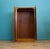 A clean mid-century two-door wardrobe in walnut, with a warm tone and simple grain. Integrated oval handles. Standing on a...