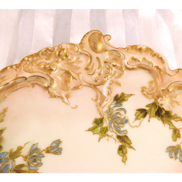 This is a Leonard plate in cream with a slightly darker cream color rim with gold trim. It has, I believe, hand painted...