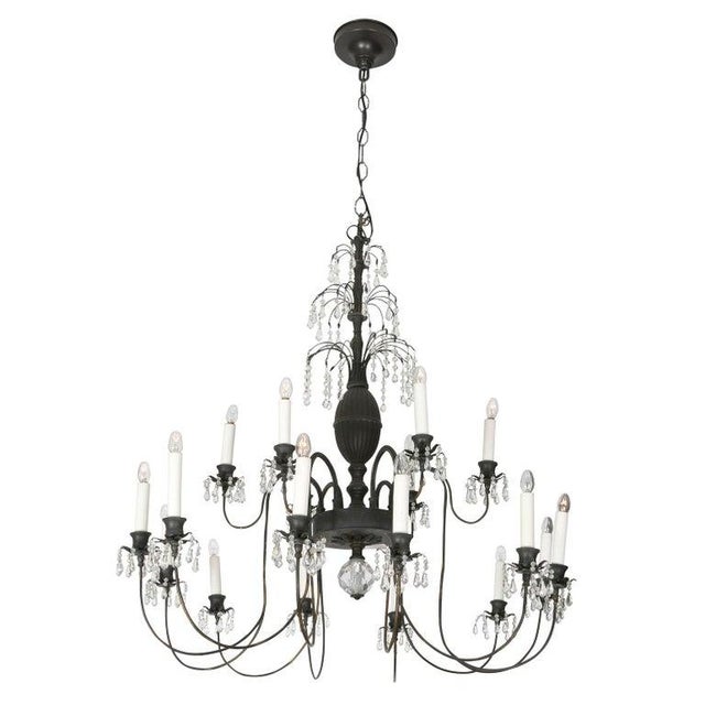 A whimsical chandelier in the Hollywood Regency style. This unique piece in bronze consists of 18 arms stemming from a...