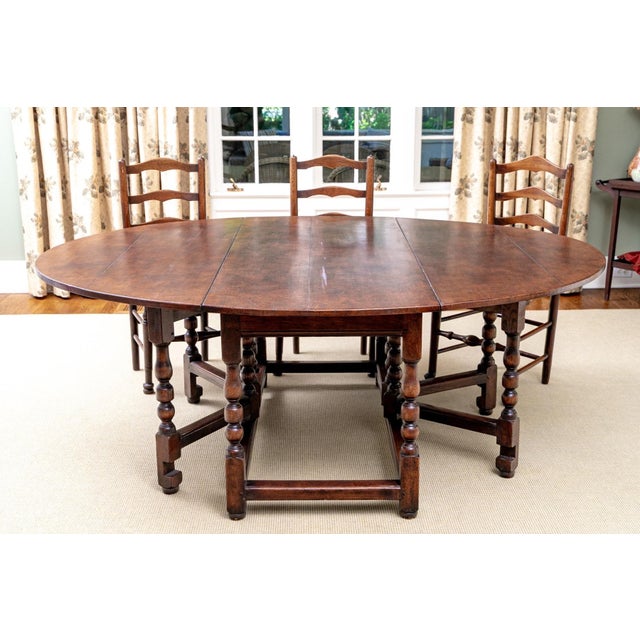 A large, heavy and very sturdy 19th century oval oak gate-leg dining table with a rich, weathered dark brown finish,...