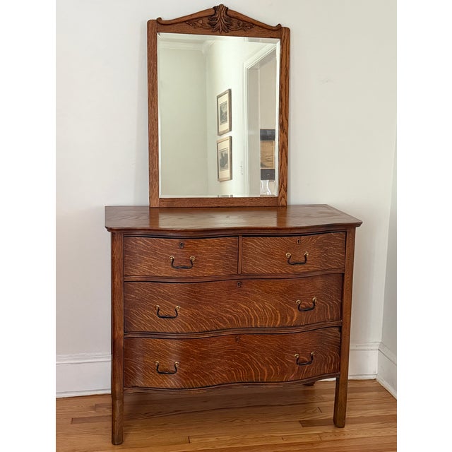 Antique tiger oak chest of drawers with serpentine drawers and original hardware. Mirror shown leaning on dresser top,...