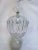 This elegant crystal hanging light features a rounded cage of vertically arranged faceted glass pieces that create a...