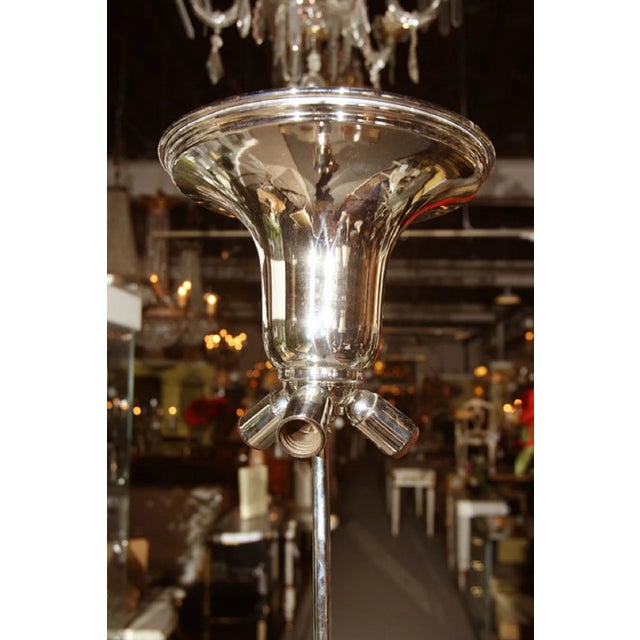 An interesting art deco style torchiere floor lamp, the chrome shade over three light sockets, standing on a cowhide...