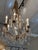 Design Plus Gallery presents a Crystal Chandelier. The chandelier has an antique gold metal frame with six lights and faux...