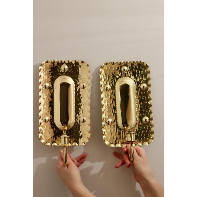 Made in Sweden A breath-taking mid-century duo of exquisite Swedish brass wall sconces, showcasing captivating hammered...