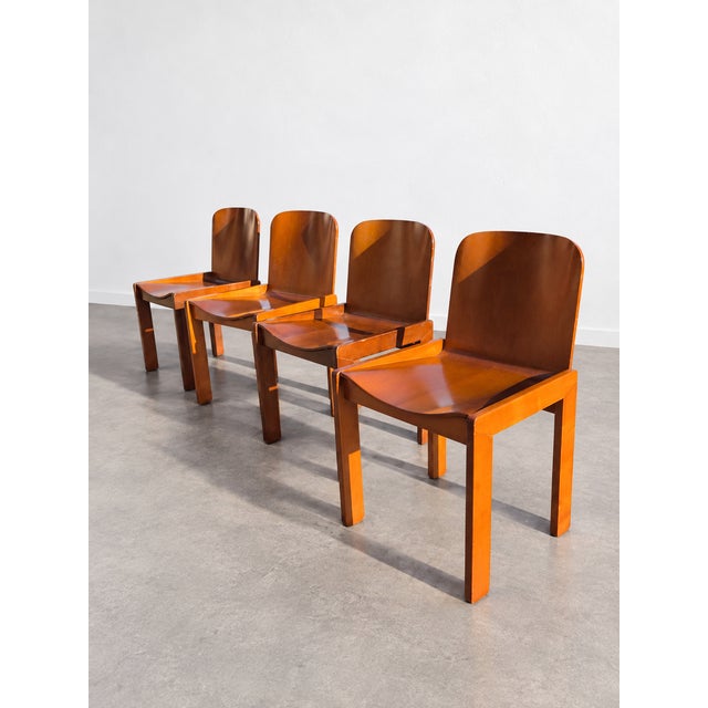 Italian dining chairs from the 1970s featuring molded plywood seats and curved backrests on a solid ash frame. The clean...