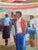 This early mid-century Latino oil painting on canvas features a central figure in a vibrant market scene, adorned with...