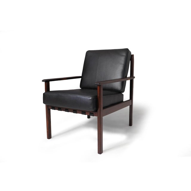 Mid-century Brazilian lounge chairs crafted from dark jacaranda, newly upholstered in black leather. The chair frames have...