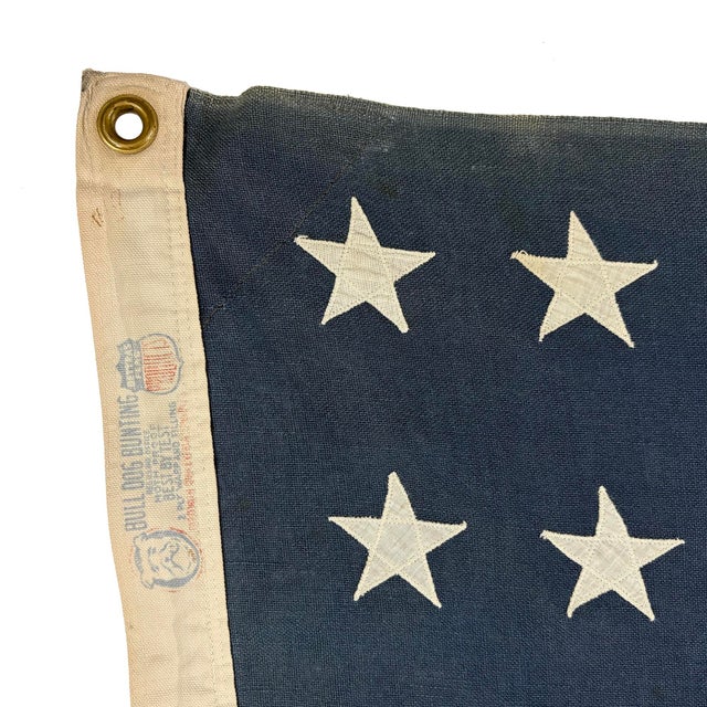 This vintage American flag is made from a cotton cloth with fully sewn stars and stripes. Please note staining,...