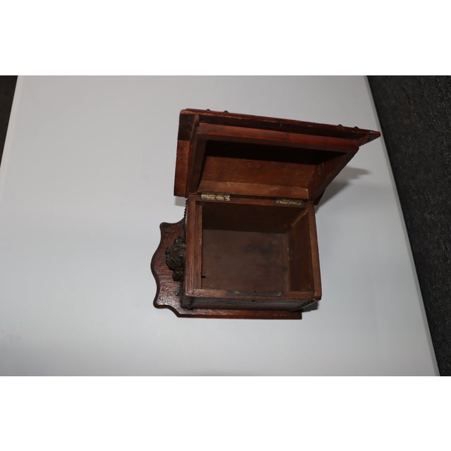 Antique Black Forest cigar humidor crafted in dark-stained wood with a hinged, pitched roof lid, carved decorative...