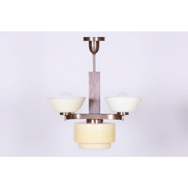 This 4-arm chandelier is a masterpiece of 1920s czechoslovak art deco. The lighting fixture presents a fascinating...