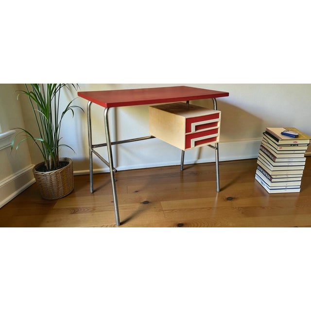 Desk dating from the 1960s. Chrome-plated tubular metal frame / Wood covered in red and white marbled vinyl. Some signs of...