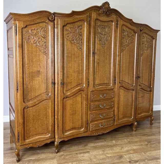 An impressive Vintage French Louis wardrobe in Oak, distinguished by its generous proportions, five beautifully shaped...