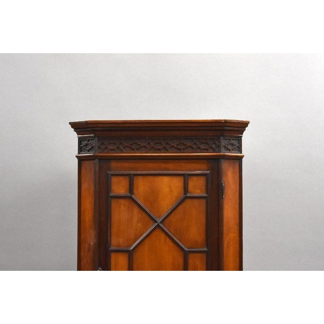 A charming Edwardian mahogany corner cabinet, dating to circa 1900, offering both elegant design and practical storage in...