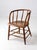 A late 1800s Windsor captain’s chair with a graceful wraparound back, turned spindles, shaped wood seat, and stretcher...