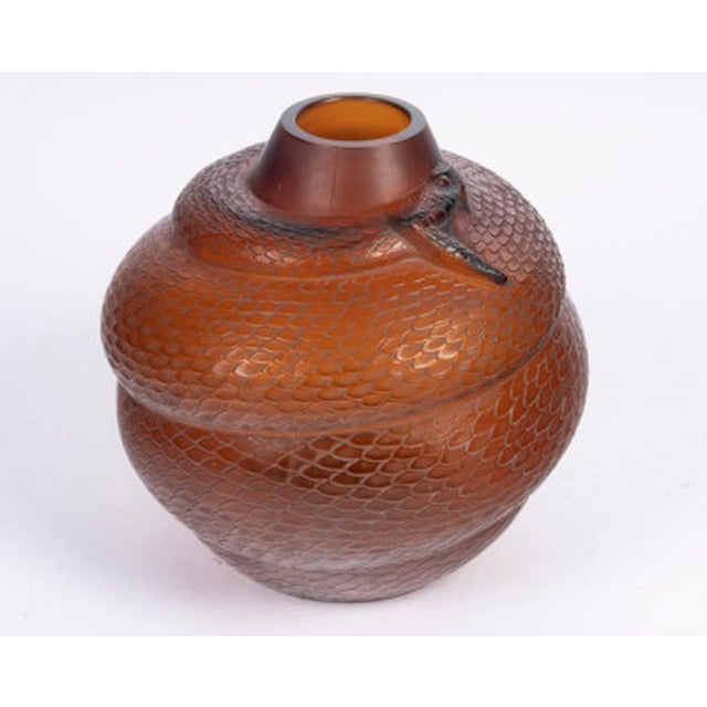 "Serpent" vase in amber-tinted glass Model created in 1924. Signature molded in relief Bibliography: Félix Marcilhac,...