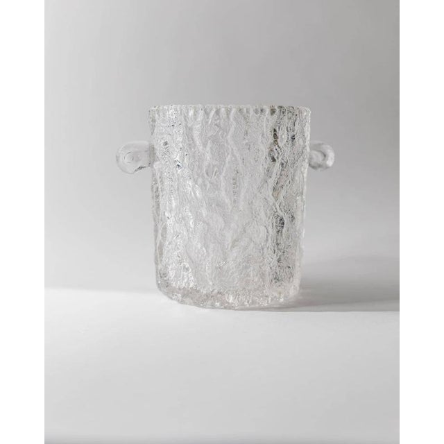 This vintage glass ice bucket or champagne cooler from the 1970s is a refined retro bar accessory with timeless appeal....