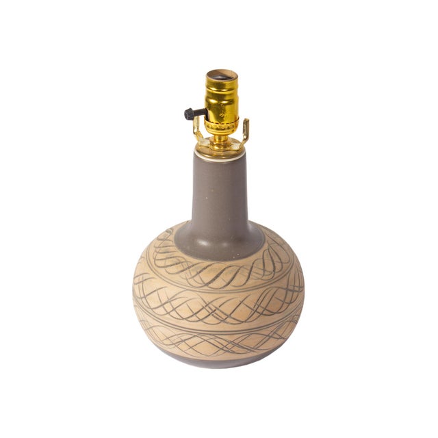A ceramic table lamp with incised design designed by American husband and wife designer duo Jane and Gordon Martz for...