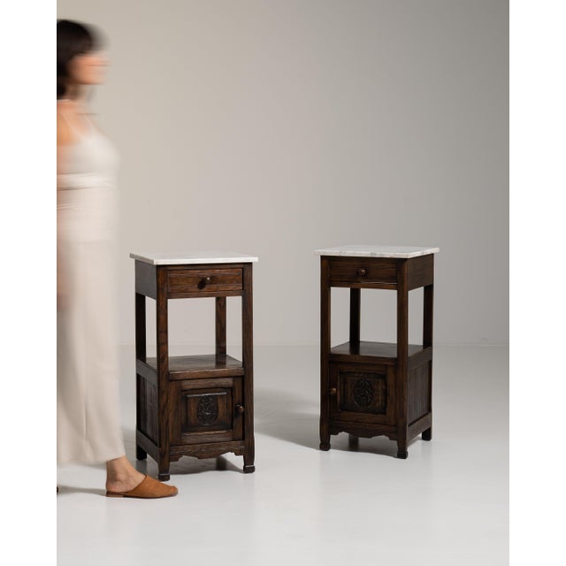 This 1900 - 1909 side table from France is finished in amber, worked in oak. It is distinguished by its marble tops, a...