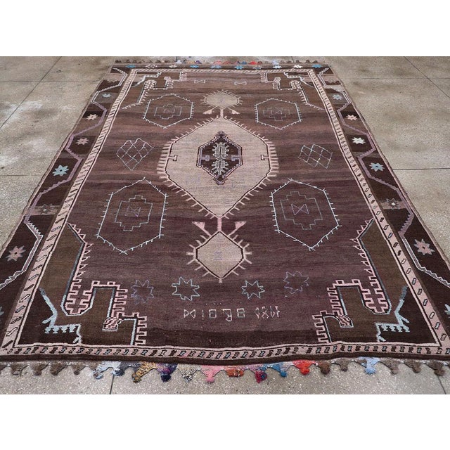 This striking Mid-20th century Turkish Anatolian tribal carpet, measuring 8' 9" x 12' 1", captures the spirit of regional...