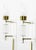 Versatile pair of Lucite and brass cylindrical wall sconces/lamps with brass rod arms that extend outward from the Lucite...
