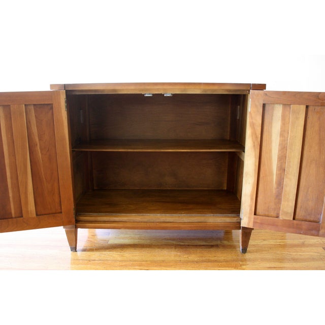 This is a mid century modern bar storage cabinet that has a beautiful framed design, two doors with brass pulls, a...