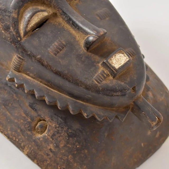 The Baule portrait mask discussed is intricately crafted for the Mblo dance, representing an honored person or ancestor in...