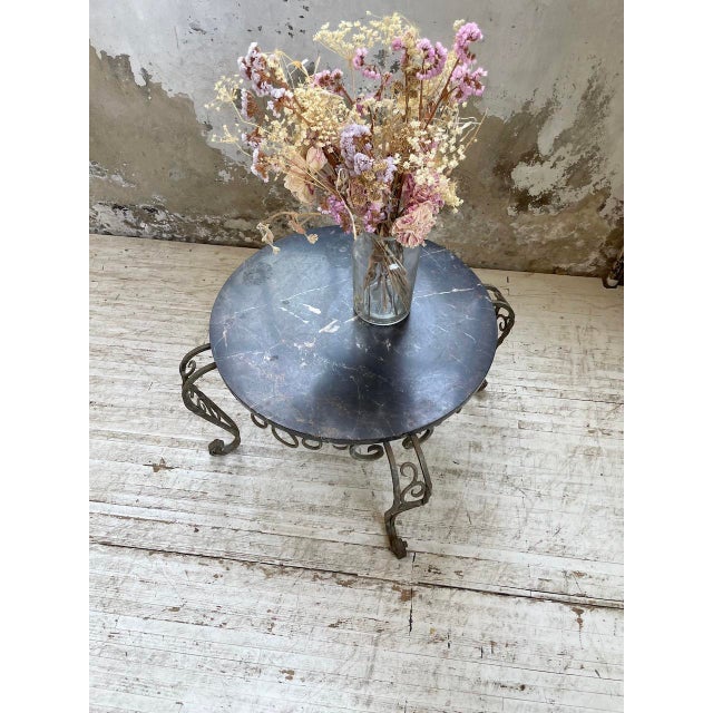 Old coffee table from the 1930s with its patinated wrought iron base with its very beautiful curves and roundings which...