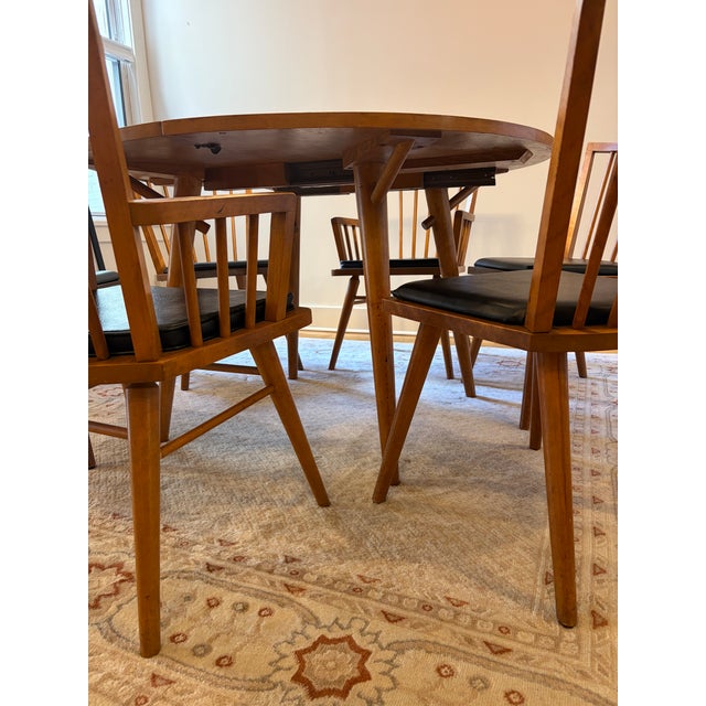 Honey tone, mid-century modern Conant Ball round dining table comes with six chairs and two leaf inserts. Almost certainly...