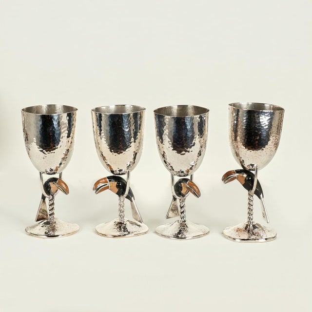 Mid century set of fourteen silver plate on hammered copper goblets featuring stone clad toucans perched in the stems,...