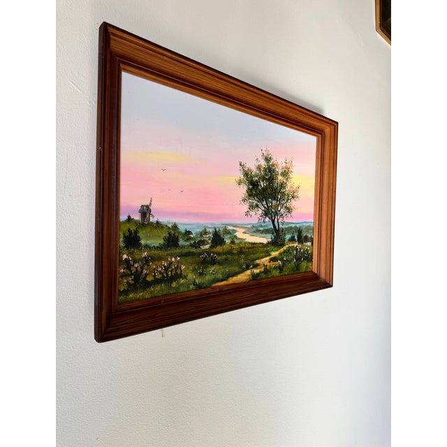 This vintage impressionist oil painting captures a serene countryside landscape bathed in the warm hues of a setting sun....