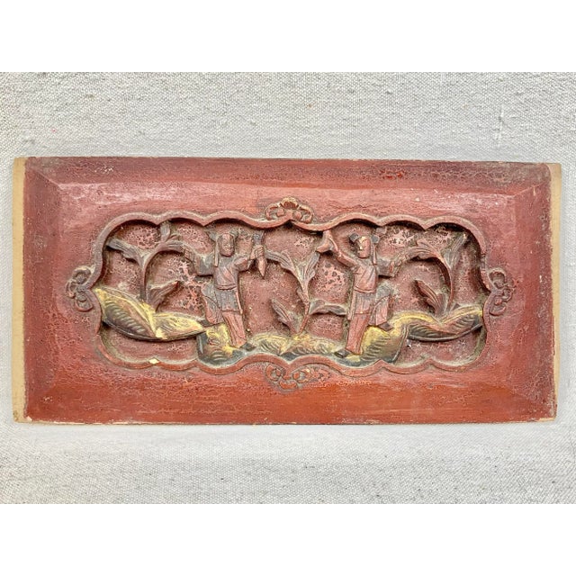 Beautiful antique carved wood wall panel. Features a chinoiserie scene. In red with yellow and black accents. Has a wall...