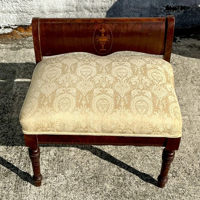 Elegant vintage Regency bench featuring exquisite wood inlay detailing and a refined silhouette. Upholstered for comfort,...