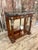 A beautiful Neo-Classic-style console table in figured walnut with a brass bordered mottled stone top and a mirrored back....