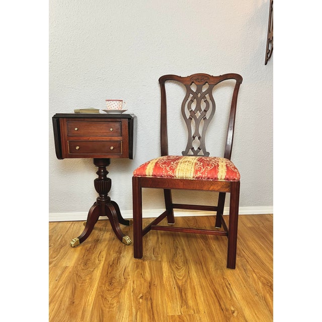 Elegant pair of early-to-mid 20th century American mahogany dining chairs crafted in the Chippendale Revival tradition....
