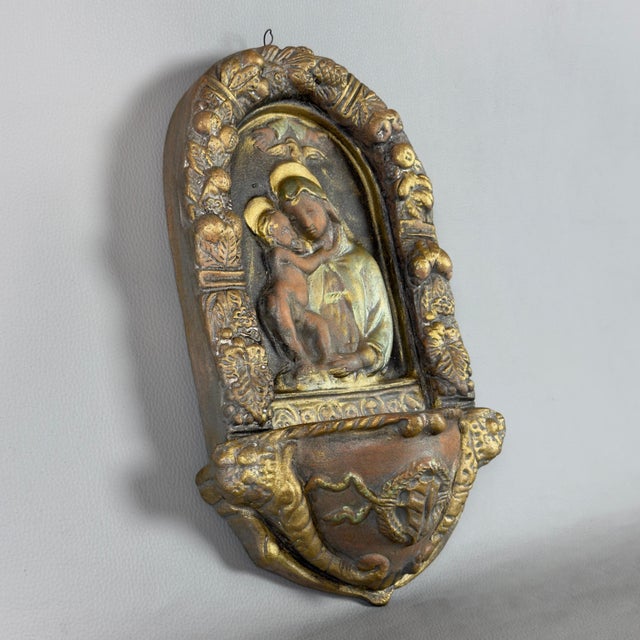 A fine and evocative terracotta wall-mounted holy water stoup, attributed to 20th-century devotional art. Subject and...