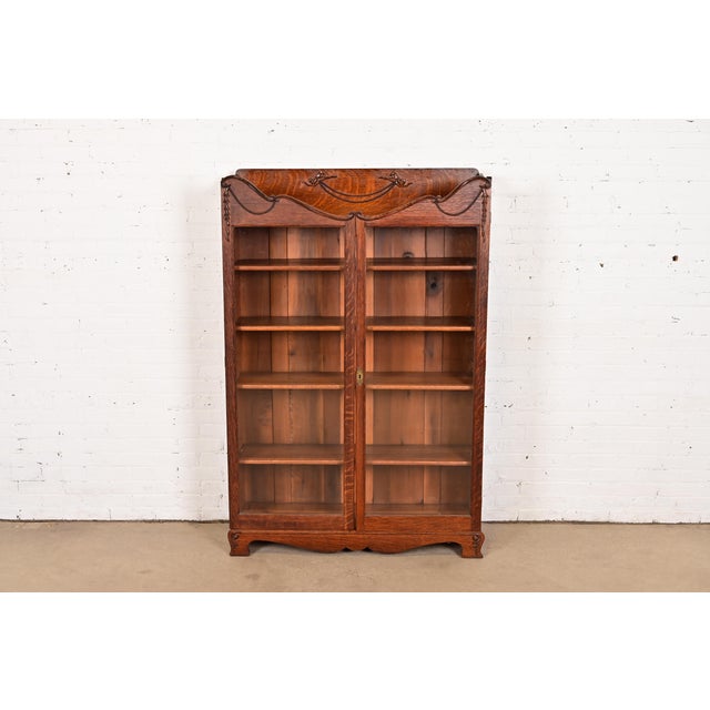 A beautiful antique Victorian bookcase or display cabinet In the manner of R. J. Horner & Co. USA, Circa 1890s Carved oak,...