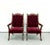 A dramatic pair of vintage high-back armchairs featuring deep burgundy velvet upholstery with generous button tufting...
