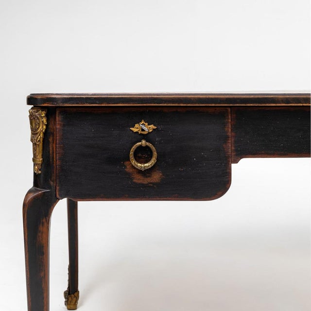Baroque-style desk with a rectangular leather writing surface and three drawers to the front. Fitted with ring pulls and...