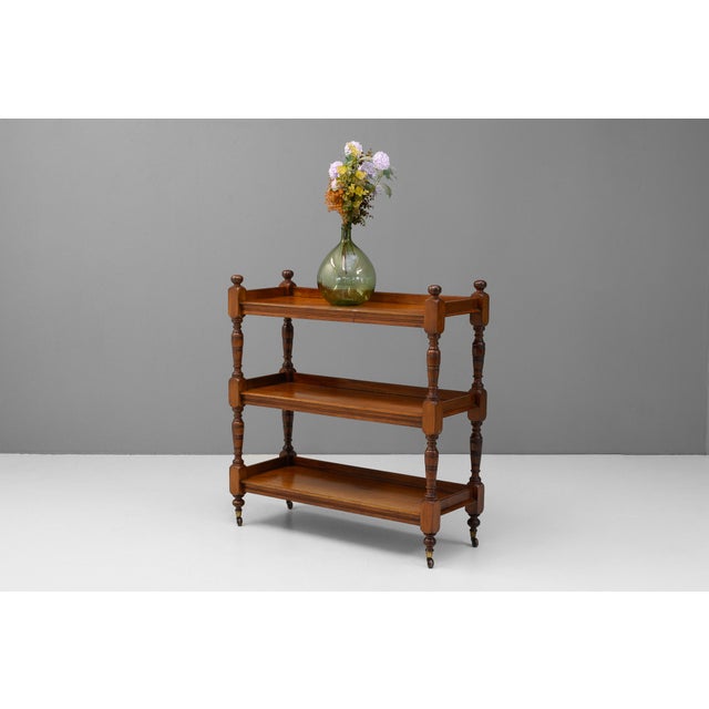 Three tier walnut buffet on pottery casters. Circa 1890.