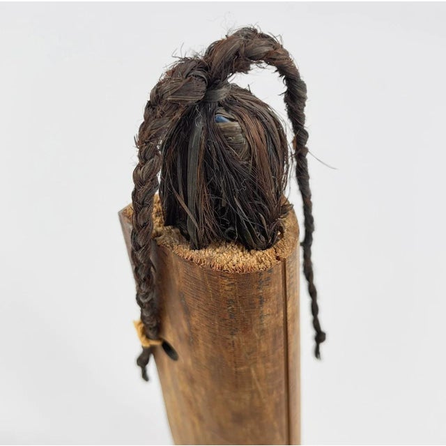 Hand-carved wooden doll from Liberia, featuring a natural raffia fiber skirt. Dolls like this are often made as...