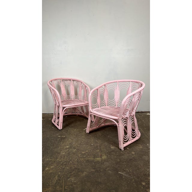 Vintage pair of rattan lounge chairs. Curved rattan frames with intricate looped pencil reed fretwork and cane wrapped...