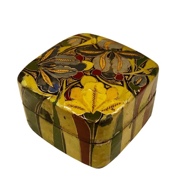 A hand painted papier mâché square box with stripes on the sides and flowers on the top. It is signed Kashmir. Circa 1960s.