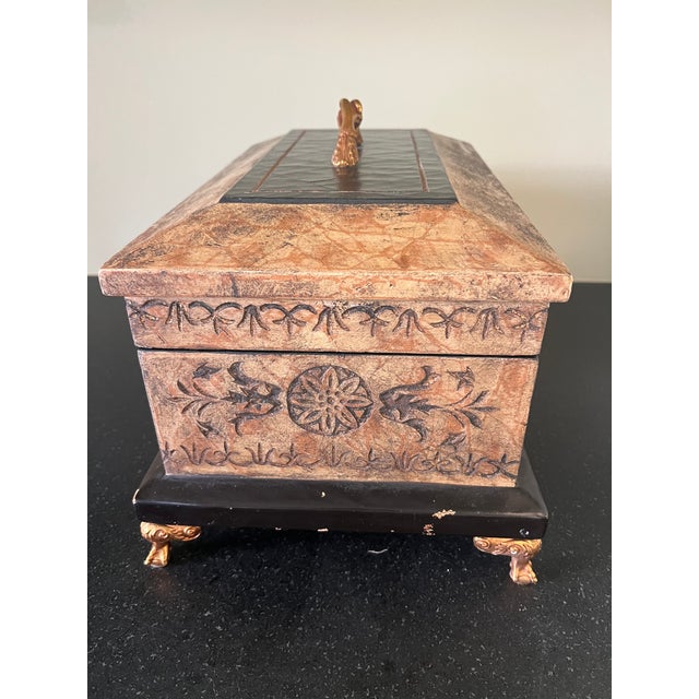 Elegant vintage Maitland-Smith decorative box featuring an intricately carved exterior, dark contrasting trim, ornate gilt...