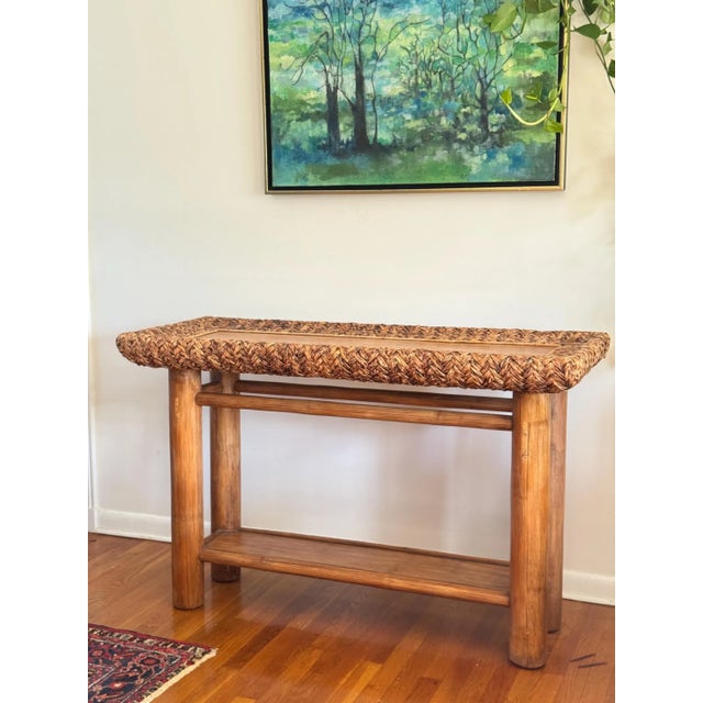 Handcrafted rustic console table constructed from solid wood and finished with a woven rattan top, substantial cylindrical...