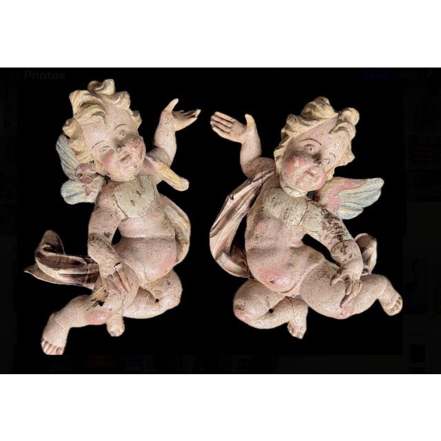 Pair of 18th Century German Baroque Carved Wooden Angel Sculptures. Each cherubic angel is depicted in dynamic, flowing...