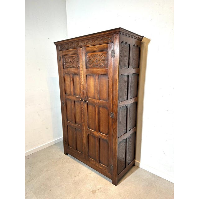 Beautiful antique wardrobe cabinet crafted in solid oak, featuring richly carved decorative panels and a warm, time-worn...