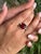 Exquisitely designed in 925 Solid Silver, this ring showcases a vibrant square Garnet gemstone measuring 10x10 mm with a...