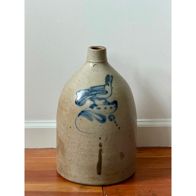 Large 19th century stoneware jug with a single handle, narrow mouth, cobalt blue bird/floral decoration, and an impressed...