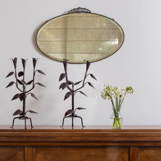 Incredible iron candlesticks from France, 1930s. Three iron arms with leaf motifs rest on a twisted stem and tripod base....